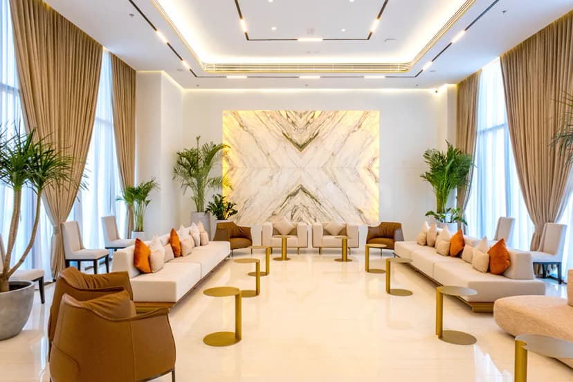 Entrance Hall at SEE Institute Dubai featuring a symmetrical layout with white sofas, brown armchairs, and a polished