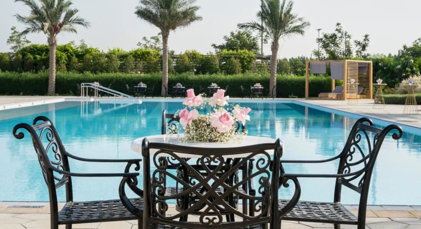 Rectangular swimming pool at Yas Acres Golf & Country Club in Abu Dhabi with pink rose centerpiece on patio