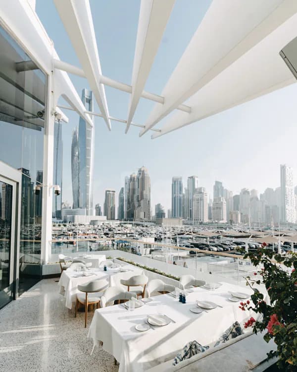 Rooftop terrace at L’Amo Bistro Del Mare in Dubai featuring a modern white canopy and marina view