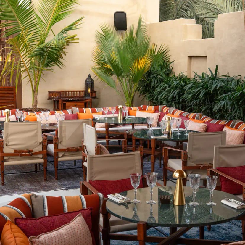 Terrace at Ninive Bab Al Shams Restaurant Dubai with potted palm trees and beige stucco walls
