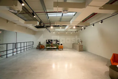 Meeting room at Slate The Space Dubai featuring an industrial ceiling with exposed ductwork and track lighting
