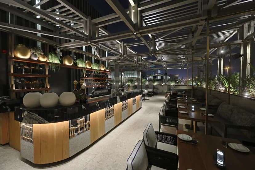 Rooftop terrace at Robata Riyadh in Riyadh with open metal-beam ceiling and city night view