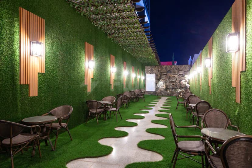 Rooftop terrace at Le Reve Hotel Taif in Taif with artificial grass and wavy tiled pathway