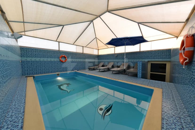 Indoor swimming pool at Garden Plaza Al Hafouf in Al Hofuf with dolphin mosaic on floor