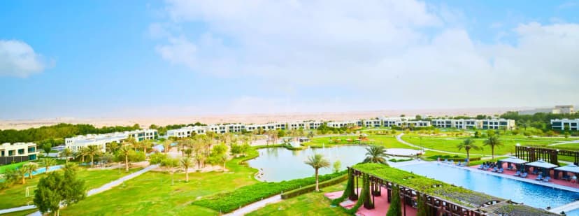 Rooftop terrace at Retaj Salwa Resort & Spa in Doha featuring a swimming pool, green-roofed wooden pergola, and desert