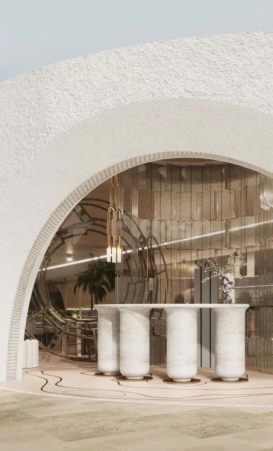 Entrance hall at San Beach Dubai featuring a white textured archway and a marble reception desk with cylindrical
