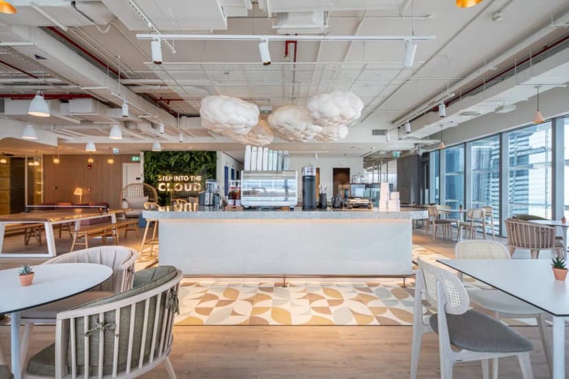 Restaurant at Cloud Spaces ADGM in Abu Dhabi featuring cloud-shaped pendant lights and a green living wall