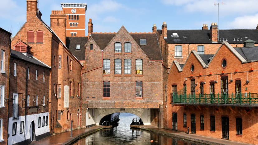 Historic red-brick buildings beside a canal in Birmingham.