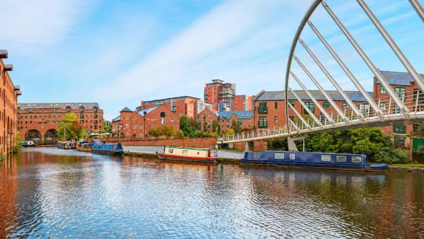 Castlefield canal, footbridge and red-brick buildings in Manchester.