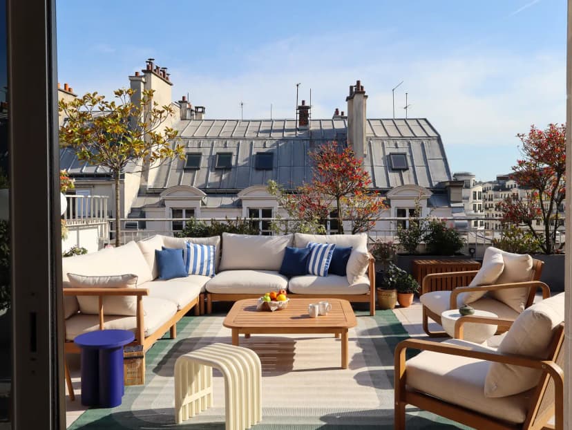 Espace rooftop avec salon extérieur et vue sur les toits parisiens